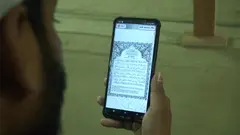 Ein Mann liest den Koran auf seinem SmartPhone.