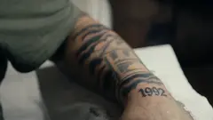Ein Unterarm eines jungen Mannes mit einem Tattoo