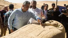 وزير الآثار المصري خالد العناني ينظر إلى تابوت تم الكشف عنه في مقبرة مصرية قديمة بالمنيا، 24 فبراير/شباط 2018. 