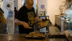 رجل في المطبخ يوزع الطعام.