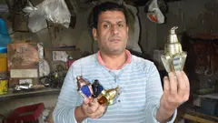A man presenting Ramadan lanterns in his workshop.  