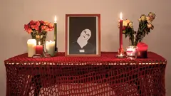 Ein Tisch mit einem Foto und Kerzen. 