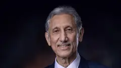 صورة لطالب الرفاعي مرتديًا بدلة أمام خلفية داكنة.