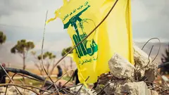 يرفرف علم أصفر على أنقاض مبنى مدمر.