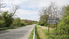 Eine Straße, rechts davon steht ein Schild mit der Aufschrift "Grenzregion" auf Englisch und Bulgarisch.