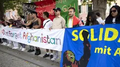 Eine Reihe Menschen hält Banner mit der Aufschrift "Don't Forget Afghanistan"