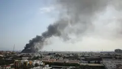 Smoke rises over a city.
