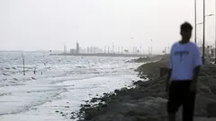 A coastline with a man blurred in the foreground.