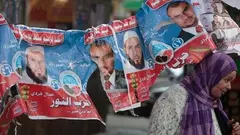 An Egyptian woman passes under electoral posters with pictures of candidates of the Salafist Al-Nour party (photo: AP/dapd)