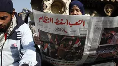 Young Egyptian reading Al-Ahram, one day after Mubarak's fall (photo: AP)