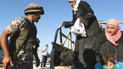 In this Saturday, Sept. 15, 2012 photo, a Jordanian soldier helps Syrian refugees who have fled violence in their country after having crossed the border into Jordanian territory with their families near the town of Ramtha, Jordan, September 15, 2012 (photo: Raad Adayleh/AP)