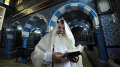 الحاخام ميمون يقرأ التوراة في كنيس غريبة في جزيرة جربة التونسية. أ ف ب