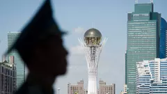 Der Byterek Turm ist sichtbar im Zentrum von Astana als ein Soldaten außerhalb des Präsidentenpalastes in Astana, Kasachstan, Wache steht, 1. Juli, 2013. David Cameron besuchte Kasachstan am 30. Juni 2013, es war der erste Besuch eines britischen Premierministers, um die Handelsbeziehungen zwischen beiden Ländern zu vertiefen, aber auch um Menschenrechtsfragen anzusprechen.  TOPSHOTS  AFP PHOTO/POOL/ LEON NEAL (Foto by LEON NEAL / POOL / AFP)