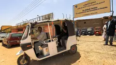 Sudanese workers test a new electric tuk-tuk.