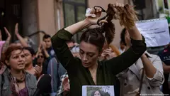 اِمرأة تجُزّ شعرَها خريف عام 2022، تضامنًا مع التظاهرات التي انطلقَت في إيران احتجاجًا على مقتل جينا مَهسا أميني عقب إلقاء القبض عليها.