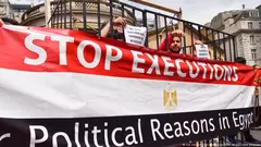 متظاهرون مقيدون يقفون بجانب لافتة "أوقفوا الإعدام لأسباب سياسية في مصر" خلال مظاهرة في لندن.