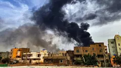 الدخان يتصاعد فوق المباني أثناء النزاع في السودان.