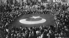 أكتوبر / تشرين الاول 1922: بعد الانتصار على اليونان يهتف الأتراك بهتافات احتفالية في مدينة سميرنا (اسمها إزمير حاليا) ومعهم علم تركي ضخم.