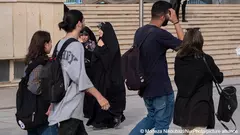 سيدة إيرانية محجبة تنظر إلى شابة غير مرتدتة الحجاب الإلزامي - معرض الكتاب الدولي عند مسجد الإمام الخميني الكبير وسط طهران - 14 مايو / أيار 2023.