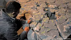 عامل في متحف الموصل في العراق يحاول إعادة تركيب قطع أثرية مبعثرة.