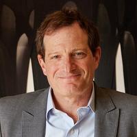 A man in a grey suit smiling at the camera.