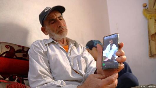 Displaced Syrian man Walid Muhammad Abdel-Baqi shows pictures of his dead son Walid on his phone
