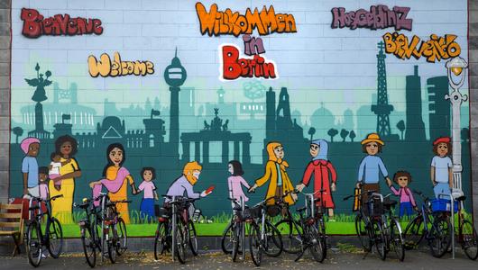 A wall of graffiti welcoming tourists and immigrants to Berlin