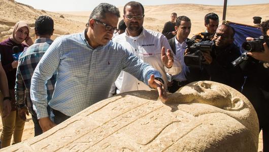 A man looks at a sarcophagus while others filming him. (Photo: Picture Alliance / Fayed El-Geziry/NurPhoto)