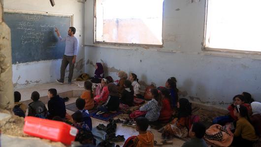 Students attend classes sitting on cold floors in classrooms with damaged walls, missing desks, doors, and windows, enduring difficult conditions to pursue their education in Idlib, Syria on October 17, 2025. (Photo: Picture Alliance / Anadolu | Kasim Yusuf)