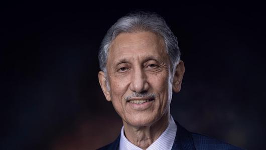 Portrait von Taleb al-Rifai im Anzug vor dunklem Hintergrund.