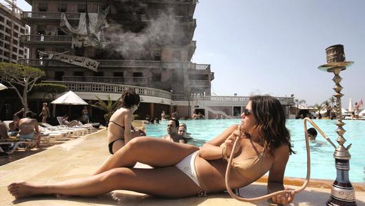 Eine Frau raucht Wasserpfeife an einem Pool. (Foto: Promo/Patrick Baz)