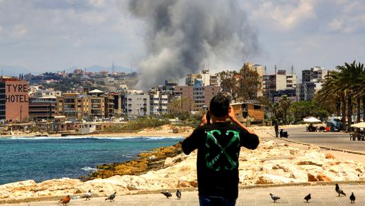Ein Libanese filmt einen israelischen Luftangriff auf die südlibanesische Hafenstadt Tyros, während die israelischen Streitkräfte ihre Invasion im Südlibanon fortsetzen – und das mitten in den laufenden direkten Gesprächen zwischen dem Libanon und Israel in Washington im Mai 2026.