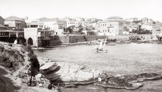 Black and white image of the Beirut seafront, with a sailing boat in the centre.
