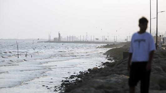 A coastline with a man blurred in the foreground.