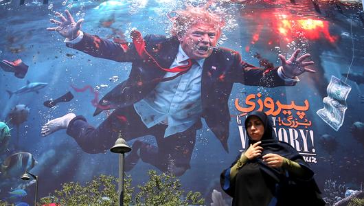 Eine Plakatwand in Teheran zeigt Trump im Wasser, davor eine Frau. (Foto: picture alliance / Anadolu | Fatemeh Bahrami))